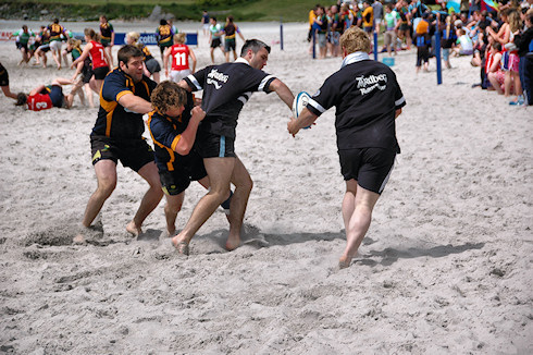 Picture of four beach rugby players in action