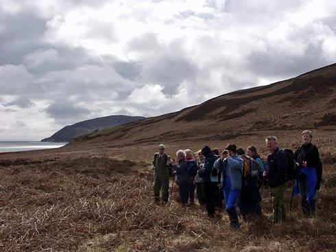 Picture of a group of walkers standing on a hillside of sound between two islands