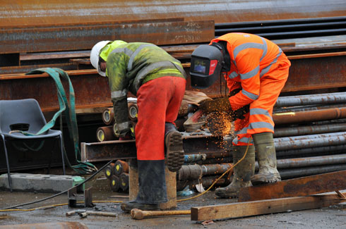 Picture of two workers grinding on a steel girder
