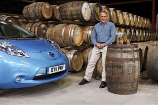 Picture of a car and a man in a whisky warehouse with many casks