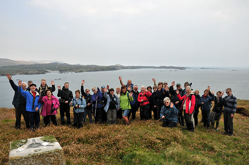 Picture of a group of walkers on a small island, a larger island in the background