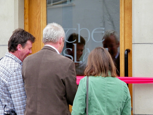 Picture of three people cutting the ribbon for a hotel called the islay