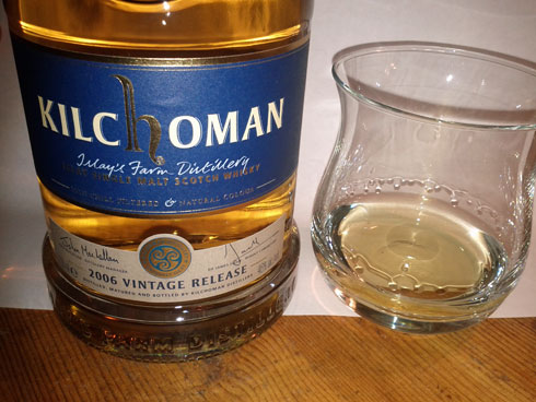Picture of a Kilchoman 2006 vintage release with a poured dram next to it