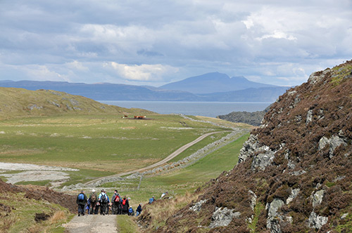 Picture of walkers on an island (Colonsay), another island visible in the distance