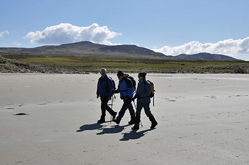 Picture of three people walking on a beach