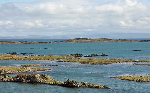 Picture of skerries off a coast, a lighthouse on one of them