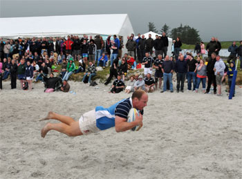 Picture of a player scoring a try in a beach rugby game