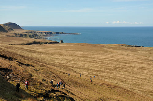 Picture of a group of walkers in a wide coastal landscape in the north of Islay
