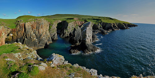 Picture of a panoramic view over a shoreline with cliffs and a sea stack