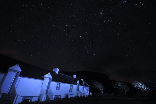 Picture of stars in the night sky over a row of cottages