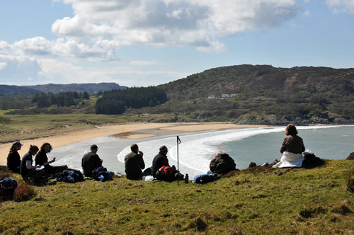 Picture of walkers having a lunch break high above a bay with a sandy beach