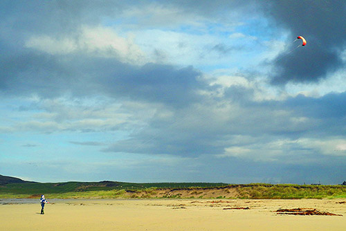 Picture of a man flying a kite on a beach