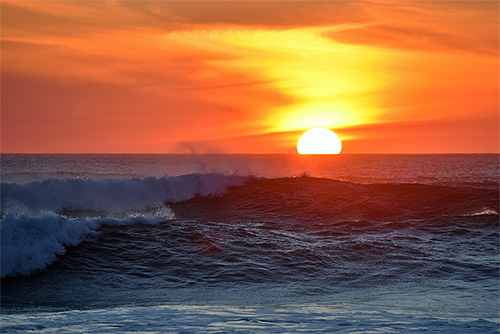 Picture of a sunset behind breaking waves